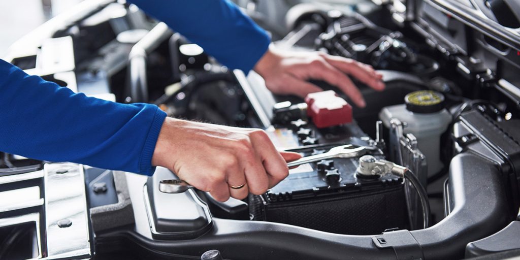 an Royal Buick GMC service employee examines an engine
